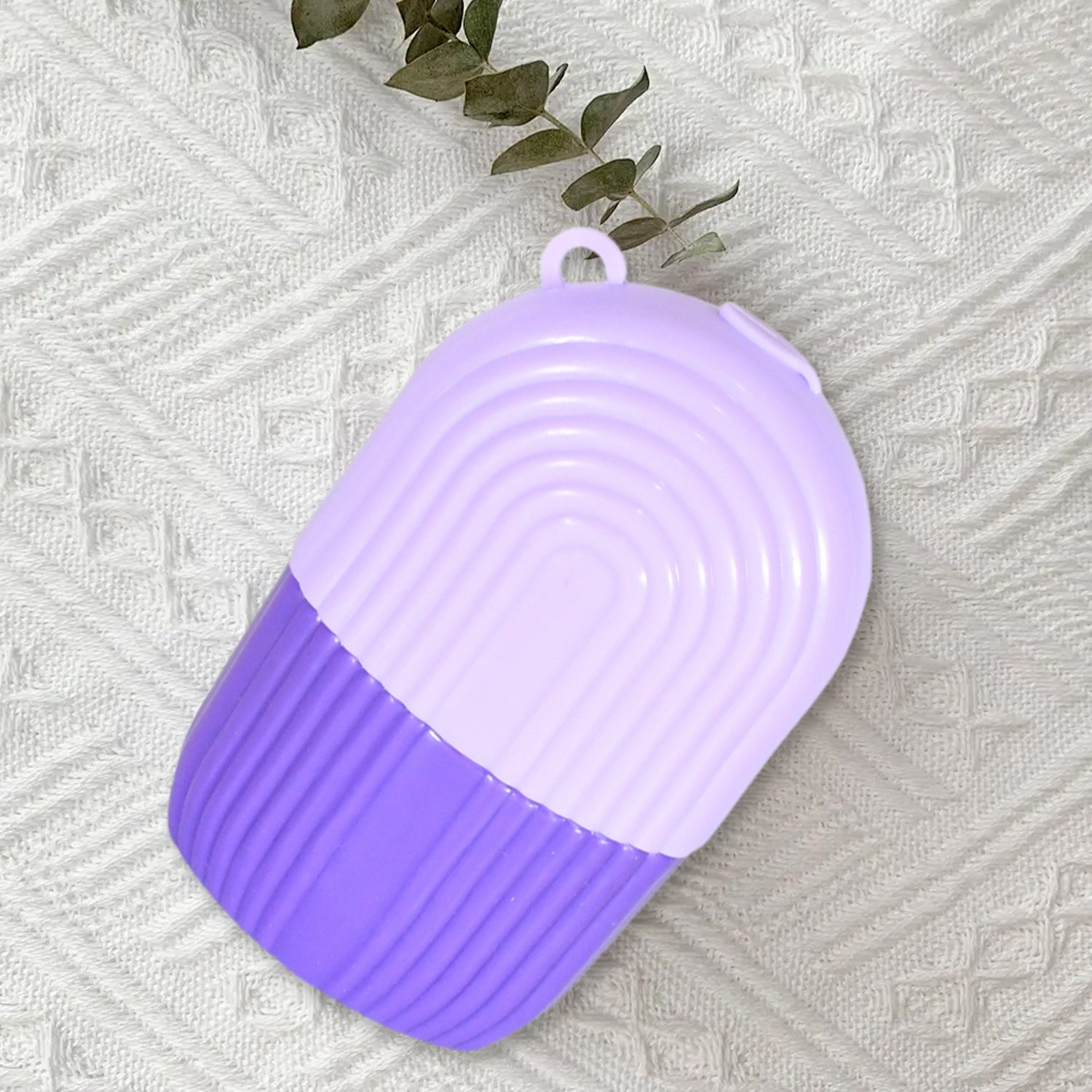 Indo Glow purple compact case for beauty ice roller face on textured white fabric background