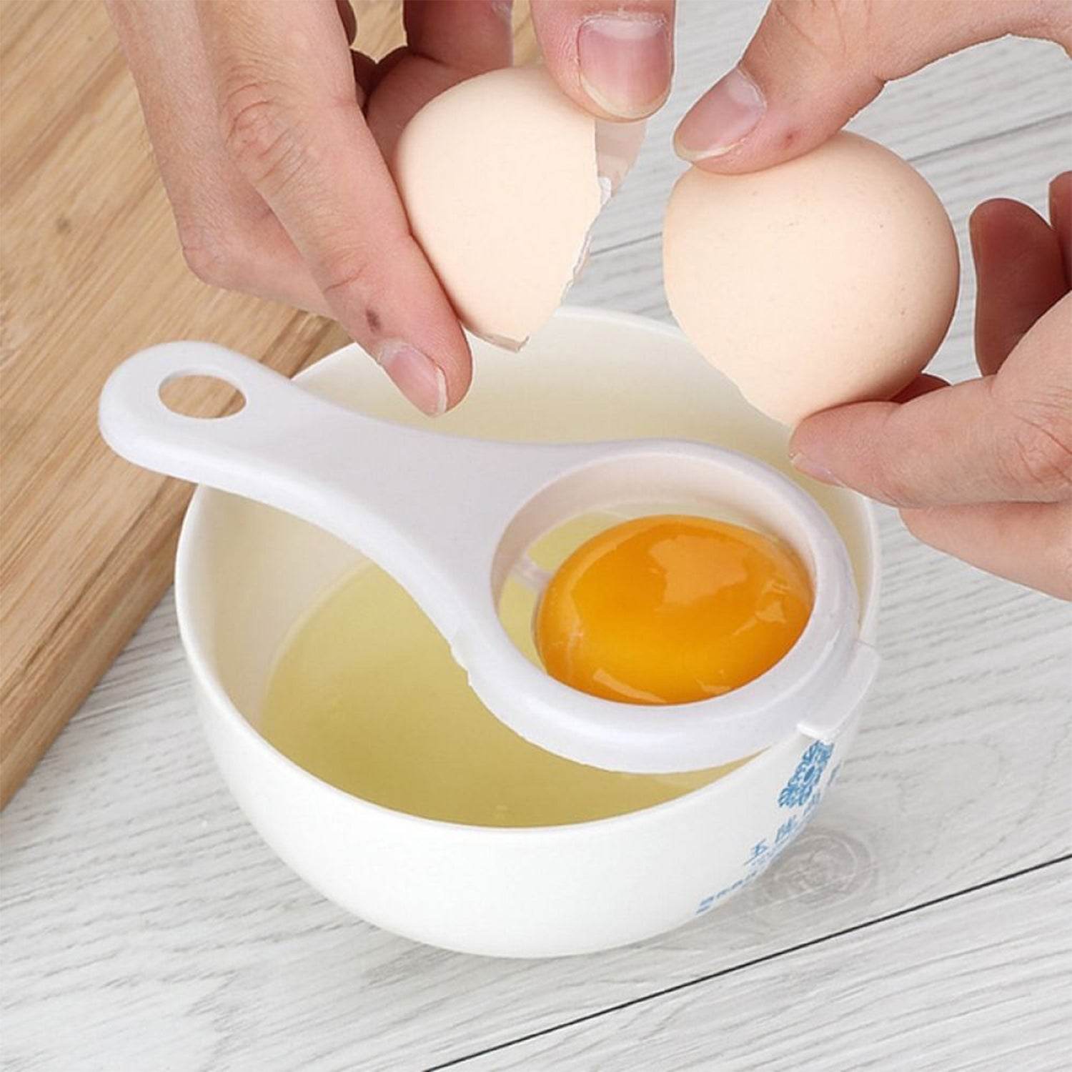 Bachat Club egg yolk separator tool catching egg yolk over white bowl on kitchen counter