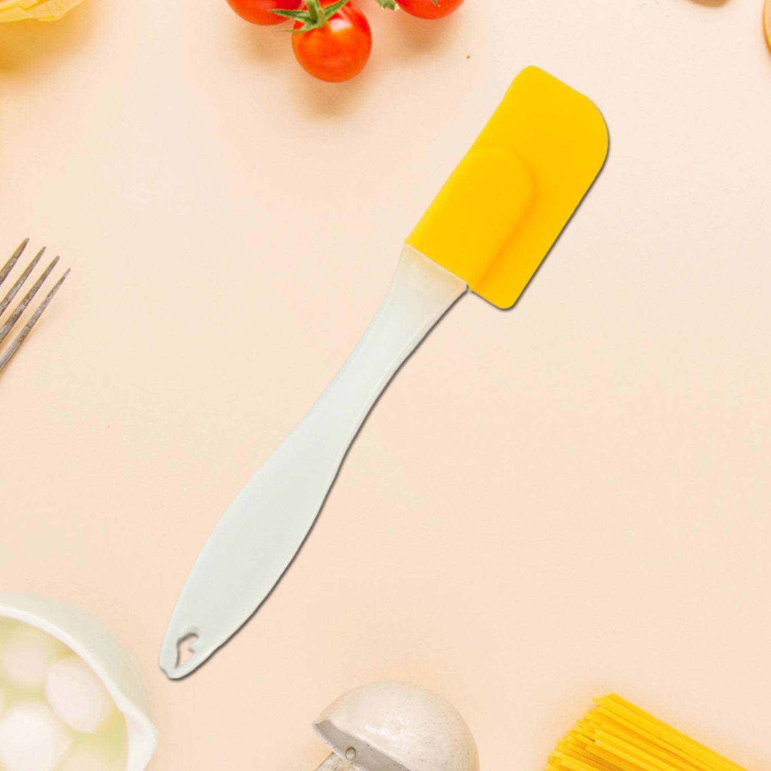 Bachat Club silicone cooking spatula with yellow head and white handle on kitchen surface